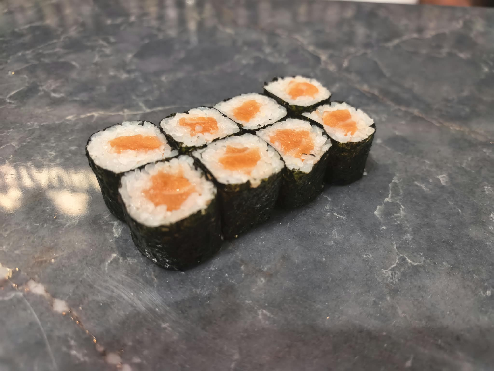 Ocho piezas de maki de salmón con arroz y alga nori